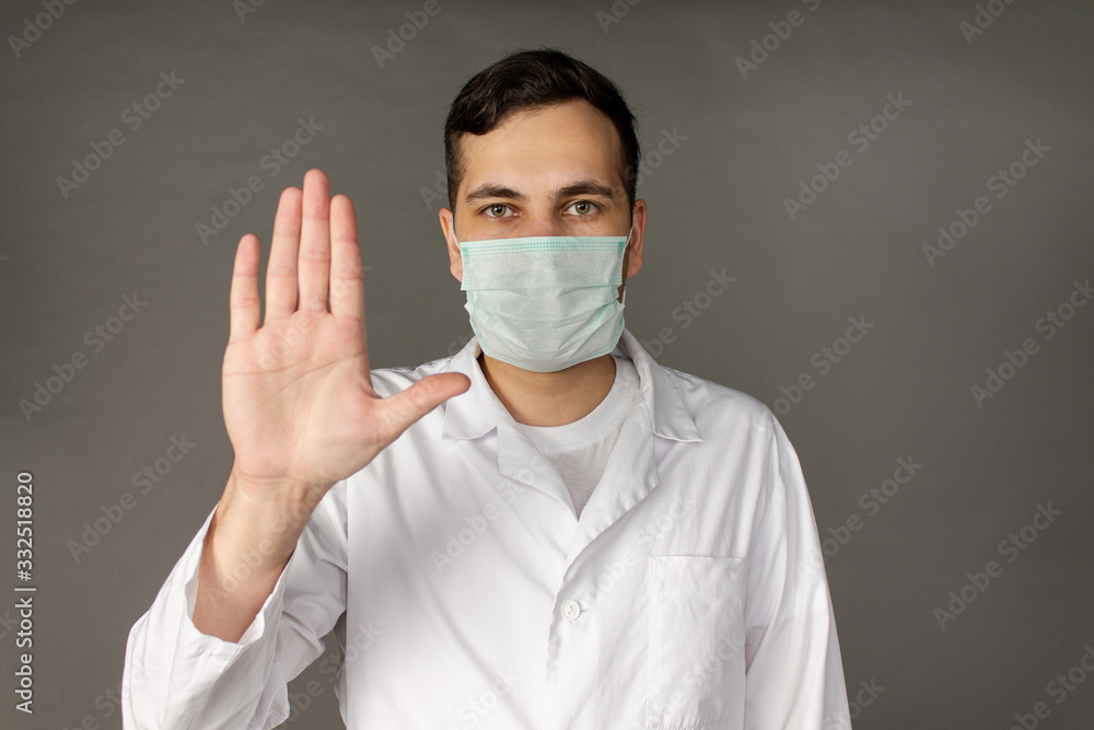 Portrait of a doctor in a medical gown clutching his head because of the number of patients with coronavirus. Portrait of a doctor in a medical gown clutching his head because of the number of patients with coronavirus.
