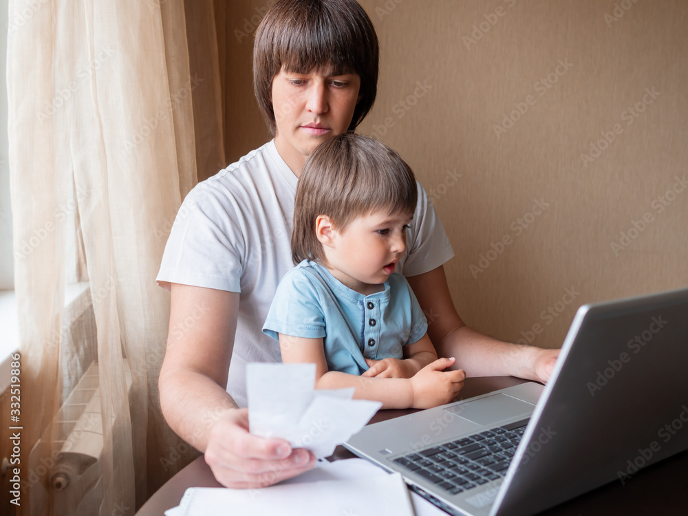 Self-isolation because of coronavirus outbreak. Man is remote working with his little son on self quarantine. Lockdown indoors. Self-isolation because of coronavirus outbreak. Man is remote working with his little son on self quarantine. Lockdown indoors.