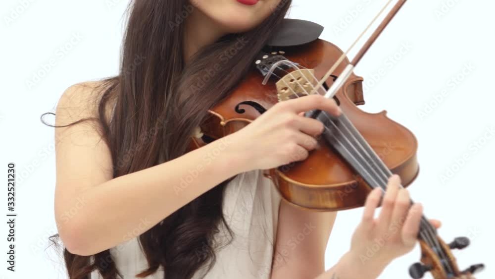 Violin in female hands, getting played by the woman at white background. Close up of bow and strings. Violin in female hands, getting played by the woman at white background. Close up of bow and strings.
