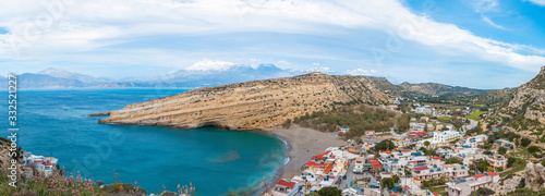 Panorama of Matala, beautiful beach on Crete island, waves and rocks. Matala village with caves and blue sky. Matala, Crete.