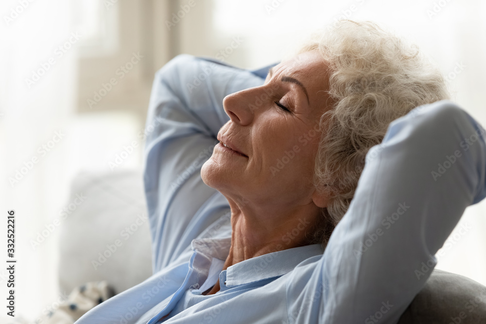 Calm mature woman sit relax on comfortable couch in living room take nap with eyes closed, relaxed elderly female rest on cozy sofa sleep breathe fresh air at home, stress free concept Calm mature woman sit relax on comfortable couch in living room take nap with eyes closed, relaxed elderly female rest on cozy sofa sleep breathe fresh air at home, stress free concept