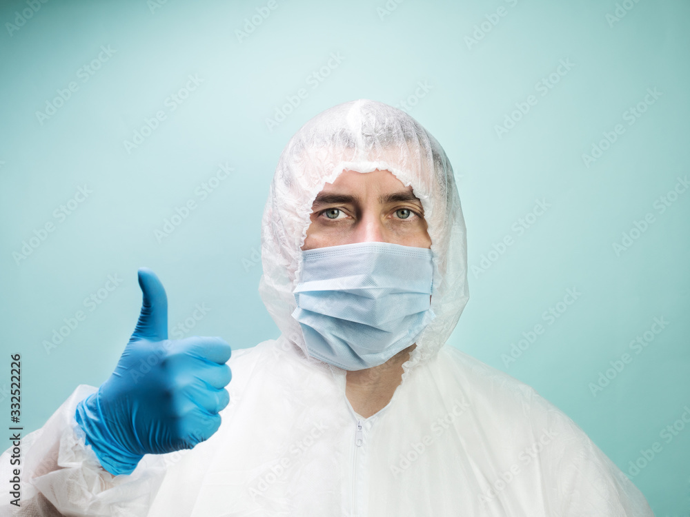 Man in protective suit and medical mask showing thumbs up Man in protective suit and medical mask showing thumbs up