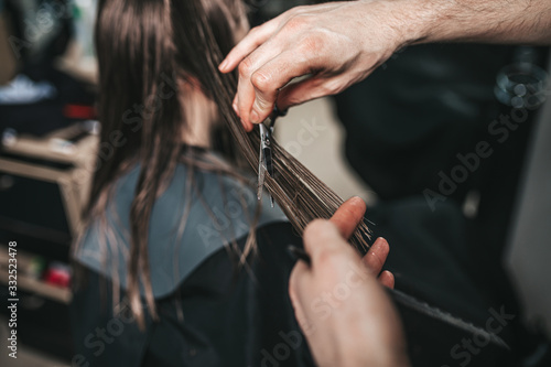 Young woman in hairsalon getting rid of split ends. Haircut.