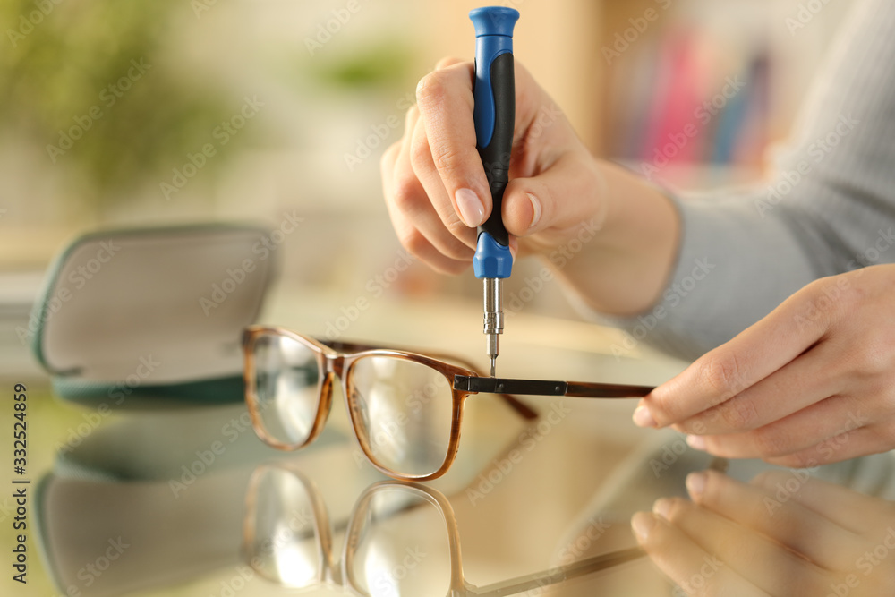 Woman hands tightening screw on glasses with screwdriver Stock Photo