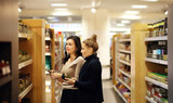 Two women choosing a dairy products at supermarket.selective focus.