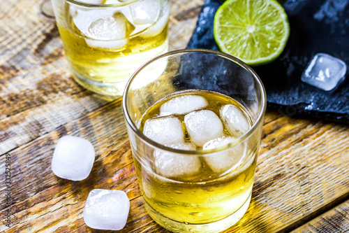 glass of whiskey on wooden background