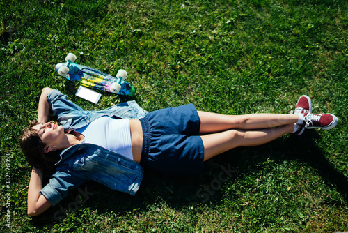 Foto Positive hipster lying on ground in park