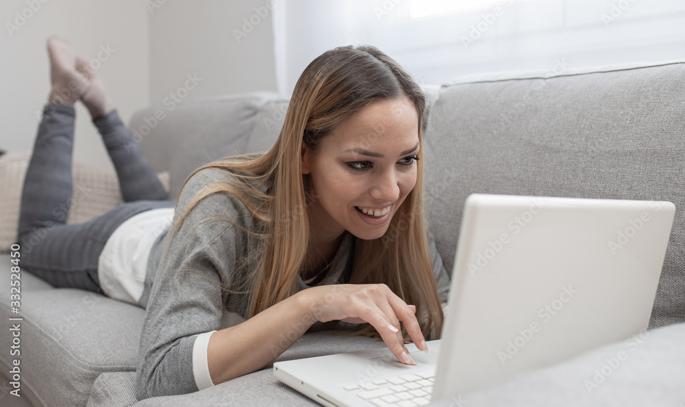 Woman using tablet on a home couch. Woman surfing on line or working from home concept Woman using tablet on a home couch. Woman surfing on line or working from home concept
