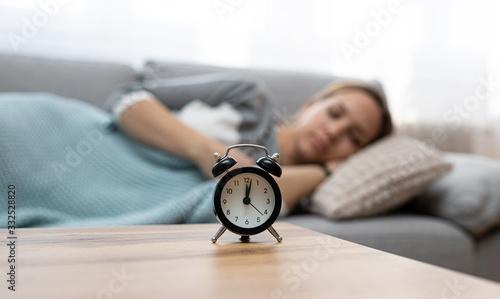 Woman sleeping peacefully. Clock in front of sleeping woman