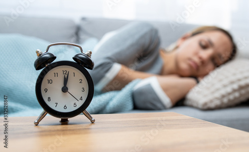 Woman sleeping peacefully. Clock in front of sleeping woman