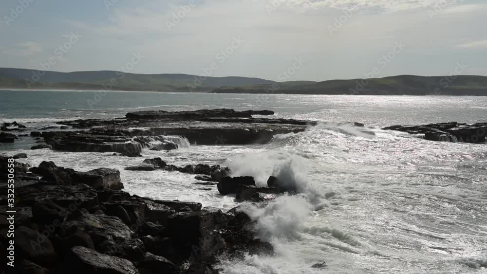 Large waves crashing into the rocky point between Porpoise Bay and Curio Bay on the Catins coast, Otago, New Zealand. Large waves crashing into the rocky point between Porpoise Bay and Curio Bay on the Catins coast, Otago, New Zealand.