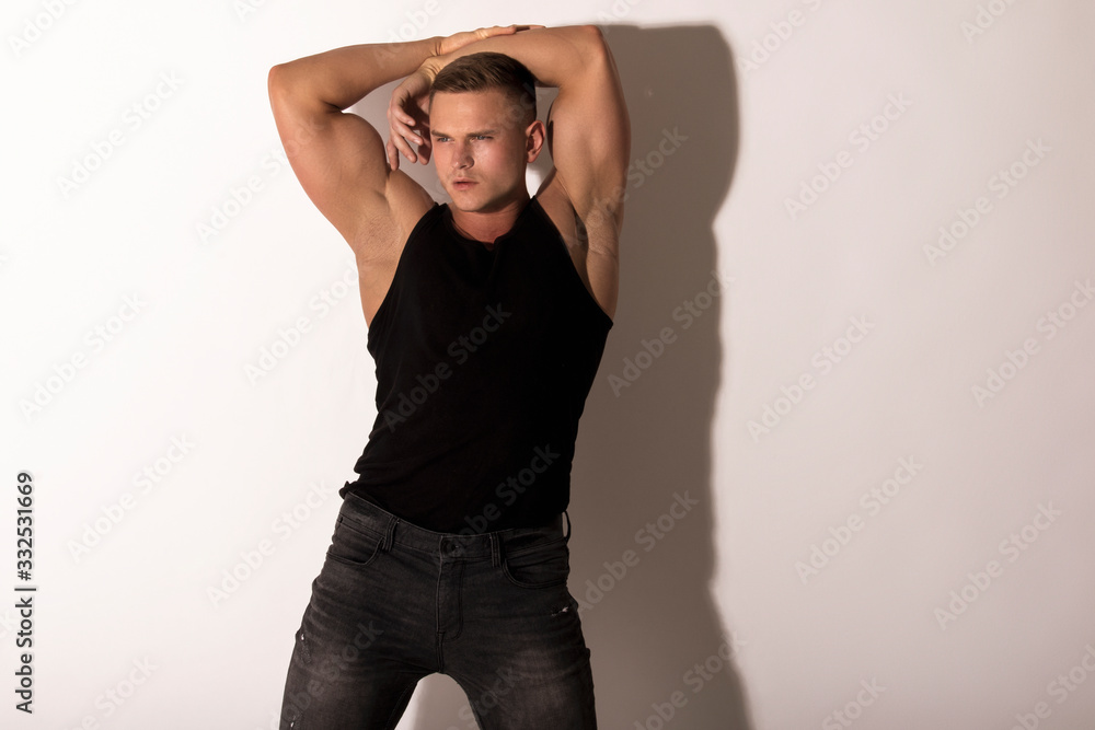 Muscle strong beautiful stripped male model with black t-shirt in denim black jeans on white isolated font background Muscle strong beautiful stripped male model with black t-shirt in denim black jeans on white isolated font background