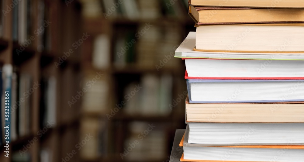 The stack ancient books on a library background The stack ancient books on a library background