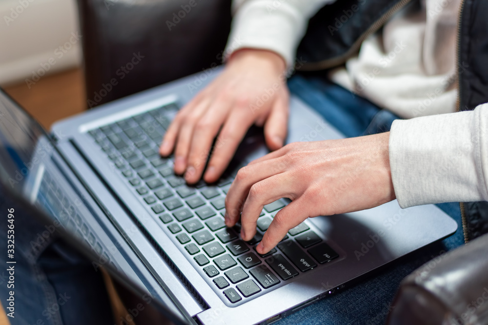 Closeup of young man using laptop at home Closeup of young man using laptop at home