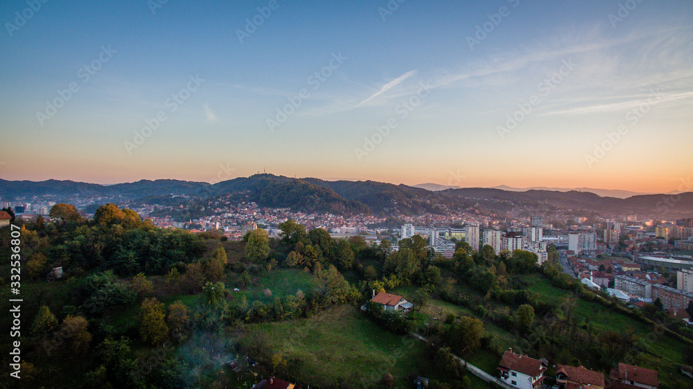 Aerial view of downtown Tuzla at sunset, Bosnia. City photographed by drone, traffic and objects , landscape.Tuzla city photographed by drone from air. Buildings near park. Old balkan city with large 