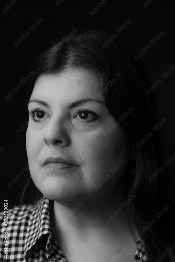 Lady head shot studio portrait. She is serious and looking away. This is a black and white image.