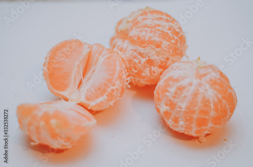 Tangerines or clementines with green leaf on white background. Peeled tangerine or mandarin fruit isolated