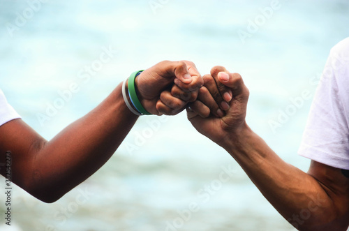 Two friends joining their fists as a prove of friendship. photo