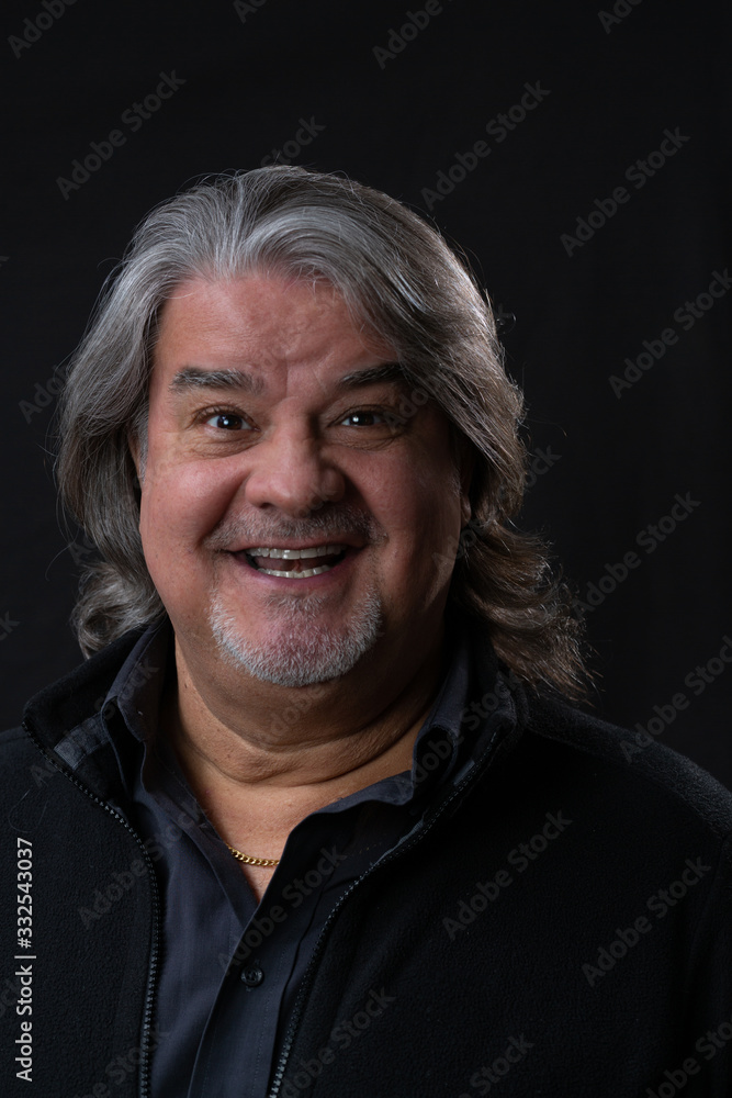 Studio head shot of man while he is smiling and looking to the camera. Studio head shot of man while he is smiling and looking to the camera.