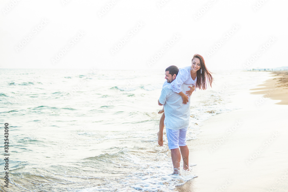 Riding on her husband. Newlywed couple in love having fun and fooling around on the sea coast Riding on her husband. Newlywed couple in love having fun and fooling around on the sea coast