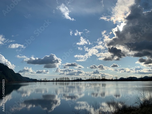 clouds over lake with reflections and some mountains