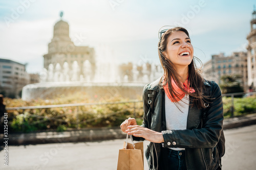 Photography Cheerful young female tourist shopping on Catalonia Square(Placa de Catalunya),La Rambla street,Barcelona,Spain