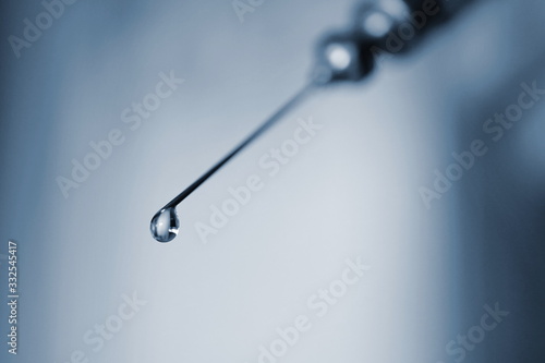 water drop on tip of a needle, vaccine, a macro zoom on the drug droplets at the tip of the needle © Robert