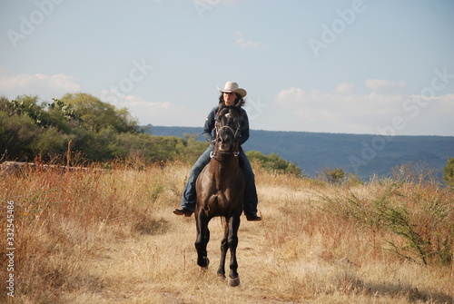 cowgirl riding horse © Cuauhtemoc