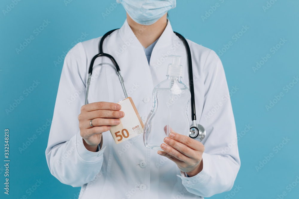 Female doctor holds money and antiseptic gel and shows financial, economic and social problem, corruption. Coronavirus concept. Female doctor holds money and antiseptic gel and shows financial, economic and social problem, corruption. Coronavirus concept.