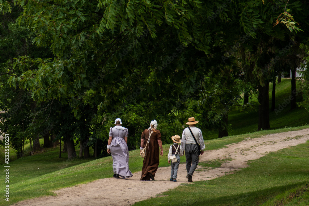 family in historic clothing  walking on trail