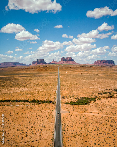 Iconic & amazing Monument Valley on the Utah & Arizona border in western United States Of America. Summer in the USA by drone, aerial view with straight road heading to famous view. 