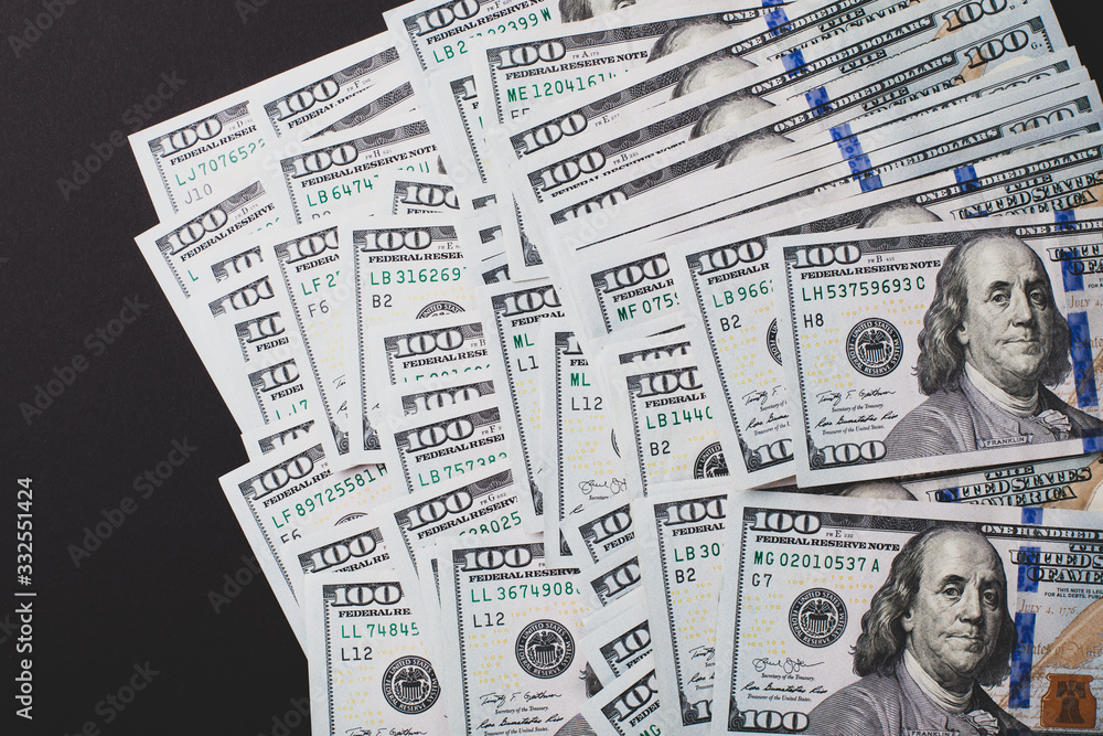 Naklejka premium A lot of dollars close up on a black background.