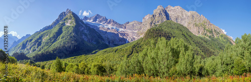 Panorama Caucasus Mountains, Dombay. Glacier, sharp peaks and forest. 