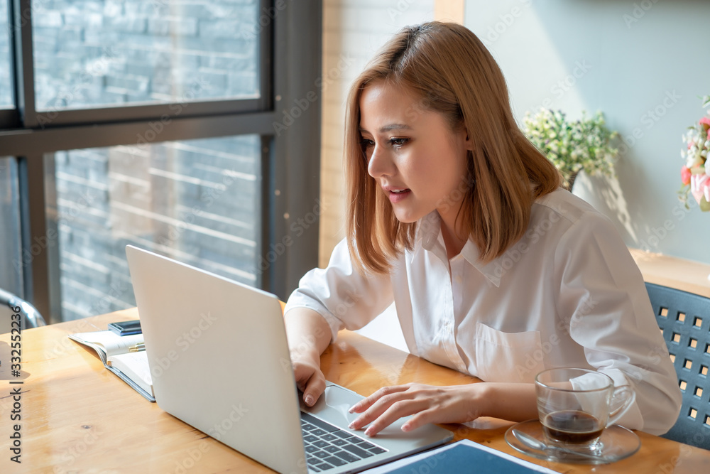 Young asian businesswoman sitting on her workplace in the office. Young woman working at laptop in the office. Young asian businesswoman sitting on her workplace in the office. Young woman working at laptop in the office.