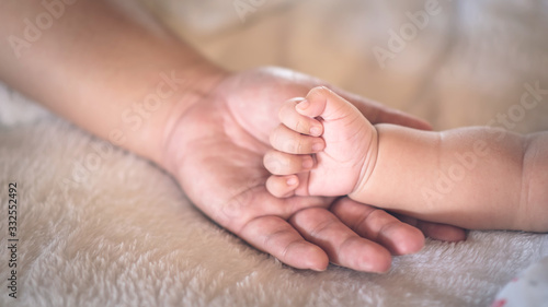 Hand of a newborn baby are on the hand of the mother. concept of love and care from mother.