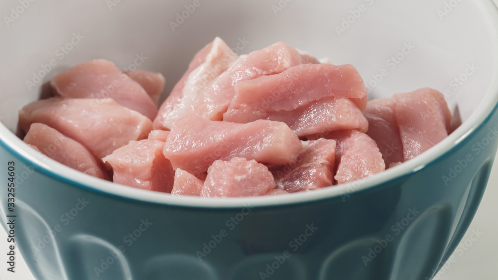 Chopped raw pork meat in a bowl - ready for cooking. Close up on white background Chopped raw pork meat in a bowl - ready for cooking. Close up on white background