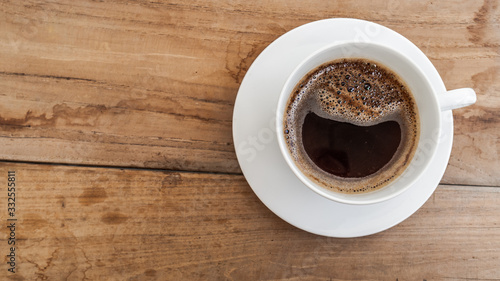 black coffee in white cup on wooden background.