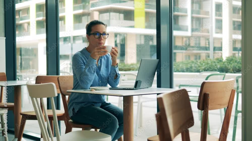 Cafe and a woman with a laptop drinking coffee Cafe and a woman with a laptop drinking coffee