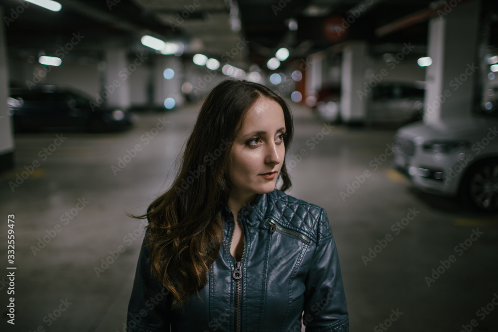 girl stands in the underground parking of a shopping center girl stands in the underground parking of a shopping center