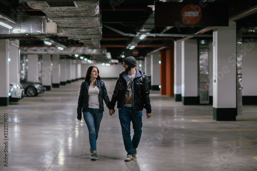 happy couple walking in the underground parking of a shopping center