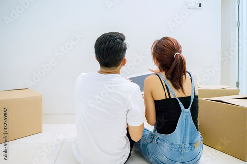 Couple sitting on the floor in their new house © Creativa Images
