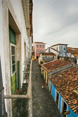 Ladeira em Salvador, na Bahia. Casas antigas coloridas. Rua estreita vista de cima. Algumas pessoas andando.