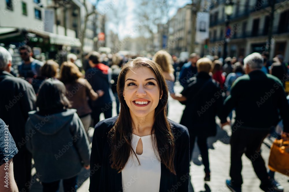 Cheerful young female tourist sightseeing in La Rambla street,Barcelona,Spain.Walking down the Barcelona's famous shopping street.Enjoying traveling.Joy in the eyes of a woman treveler.