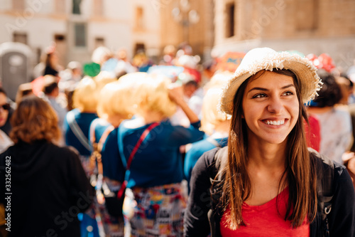 Cheerful tourist visiting to the public celebration,attending carnival.Carnival season.Crowd in costumes traditionally parading street festival.Masquerade in Europe.Colourful vacation photo