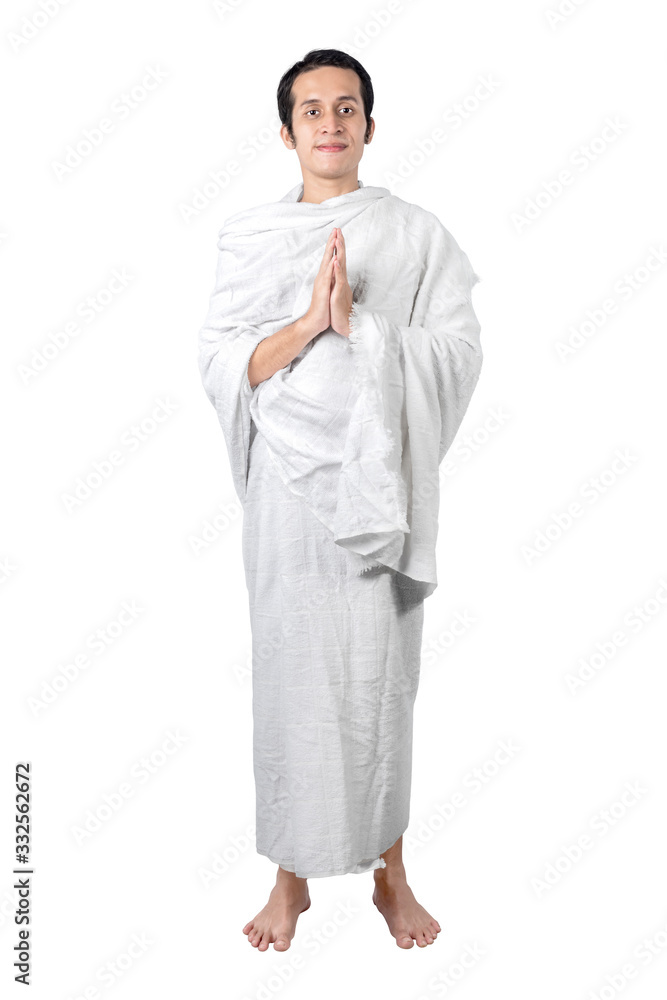 Asian Muslim man in ihram clothes standing and praying Asian Muslim man in ihram clothes standing and praying