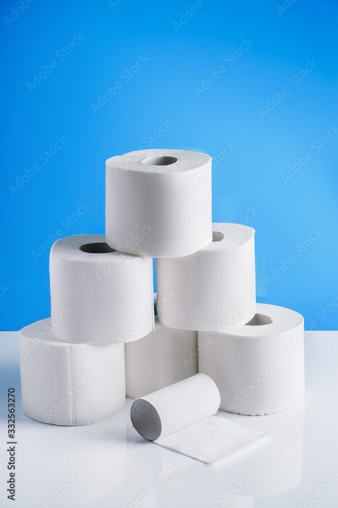 Rolls of toilet paper on a blue background. Panic purchase of essential goods. The coronavirus epidemic. Rolls of toilet paper on a blue background. Panic purchase of essential goods. The coronavirus epidemic.