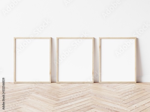 Three vertical wooden frame poster on wooden floor with white wall. 3 frame mock up. 3D illustration.