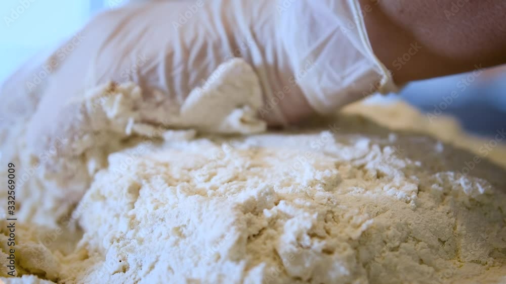 Female hands kneading dough in flour on table Female hands kneading dough in flour on table