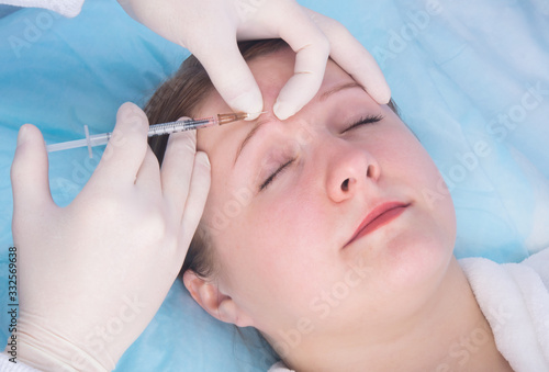 cosmetology, injection into a woman's eyebrow to accelerate their growth