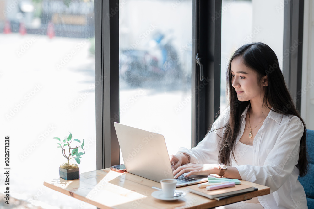 young woman using laptop computer while sitting at cafe background, technology and lifestyle. Beautiful young business woman looking at her laptop. young woman using laptop computer while sitting at cafe background, technology and lifestyle. Beautiful young business woman looking at her laptop.